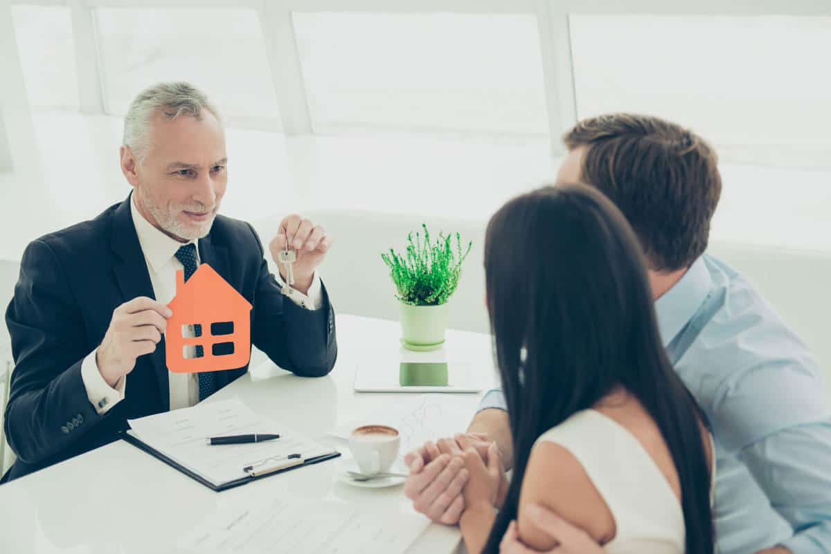 man-giving-consultation-to-people-selling-a-house-We-Buy-Houses 67953679-successful-lawyer-giving-consultation-to-family-couple-about-buying-house